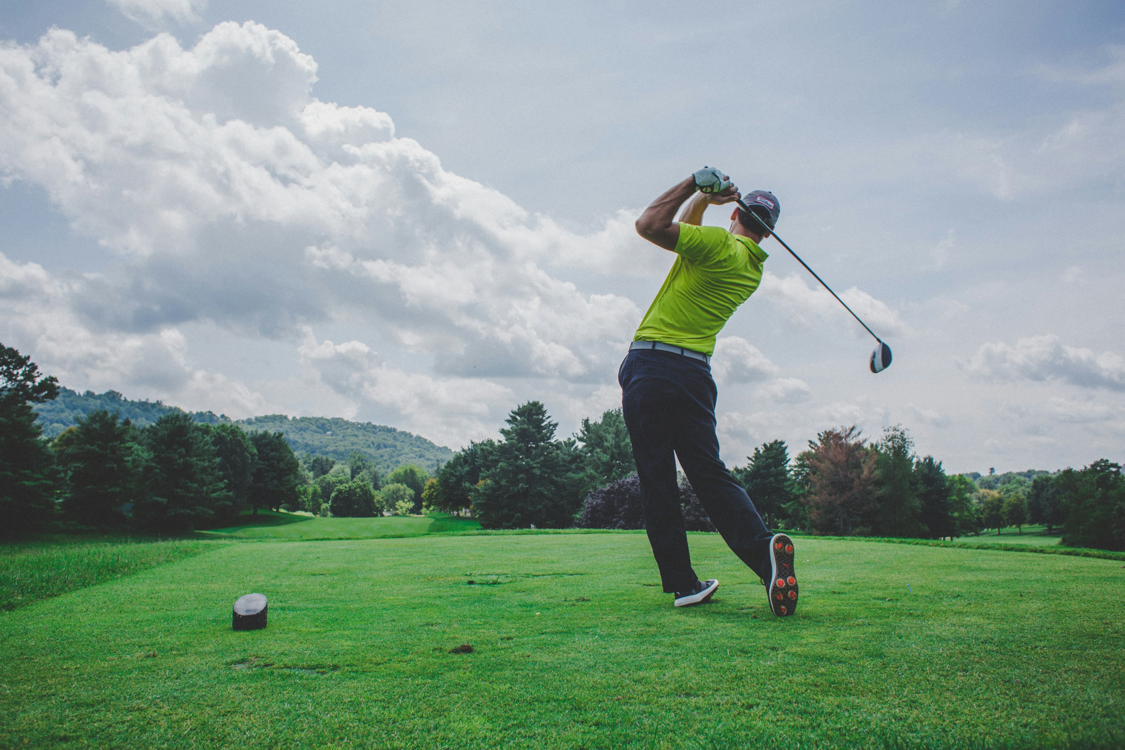 Golfer following through against a mountain backdrop